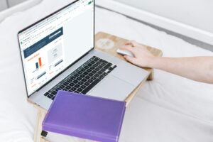 une personne utilisant un ordinateur portable sur un lit